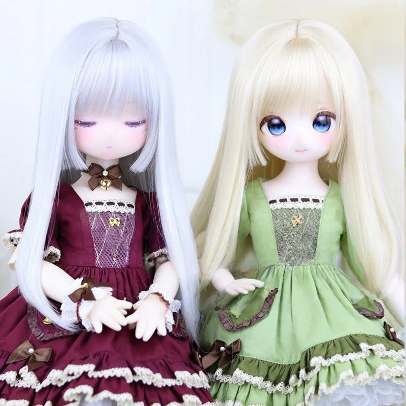 Two ball-jointed dolls in lace-trimmed dresses, one burgundy and one green, with long hair.