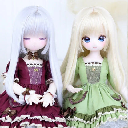 Two ball-jointed dolls in lace-trimmed dresses, one burgundy and one green, with long hair.